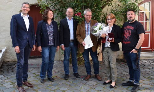 Karen Haase zeigt ihre Ehrenplakette. Feiern wollte sie entspannt im kleinen Kreis mit Oberbürgermeister Dr. Oliver Junk (von links), Marion Siegmeier, Mathias Brand, Ehemann Gerhard Haase und Giovanni Graziano. Foto: Stadt Goslar
