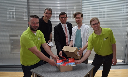 Stadtjugendpfleger Martin Sänger, Oberbürgermeister Dr. Oliver Junk, Jens Müller von der Sparkasse Hildesheim Goslar Peine, Michael Helmbrecht, verantwortlich für das Layout und Joshua Friederichs von der Stadtjugendpflege enthüllen den frisch gedruckten Ferienpass. Foto: Stadt Goslar