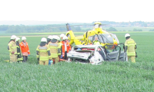 Der Rettungshubschrauber und die Feuerwehr am Unfallfahrzeug
Foto: Polizei Wolfsburg