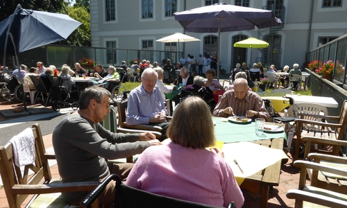 Die Bewohner und Gäste des Grillfestes auf der Brücke der Seniorenbetreuung Schloß Schliestedt. Im Hintergrund der Grillstand der hauseigenen Küche. Foto: Privat