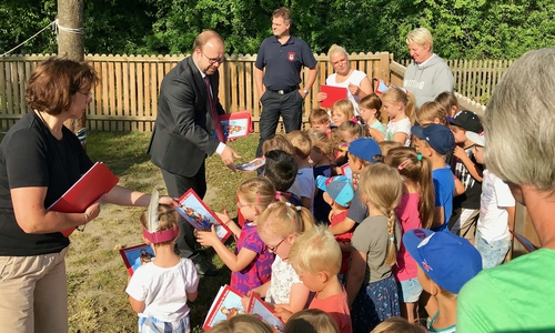 Kita-Leiterin Petra Kaul, FIBAV-Geschäftsführer Jens Fischer und stellvertretender Stadtbrandmeister Matthias van der Wall überreichten die Brandschutzbücher an die Kinder (v. li.). Foto: FIBAV