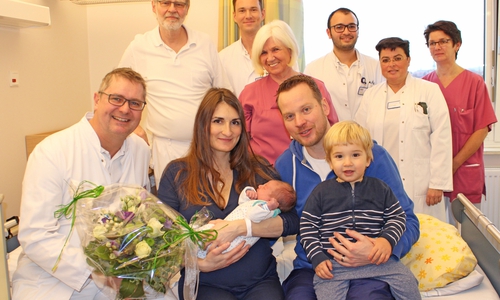 Das Team der Klinik für Gynäkologie und Geburtshilfe um Chefarzt Matthias Buhles (1.v.l.) mit den Eltern Tihana Tasic und Markus Steingröver sowie Brüderchen Luka. Foto: Städtisches Klinikum
