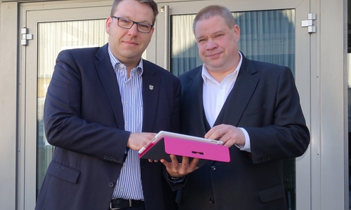 Helmstedts Bürgermeister Wittich Schobert und Graslebens Samtgemeindebürgermeister Gero Janze testen den freien WLAN-Zugang mit dem Tablet vor dem Grasleber Rathaus. Foto: Samtgemeinde Grasleben. 