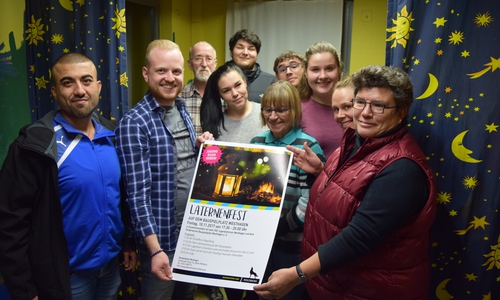 Mitarbeiter vom Bauspielplatz Westhagen sowie Ehrenamtliche desFördervereins präsentieren das Plakat zum diesjährigen Laternenumzug. Foto: Stadt Wolfsburg