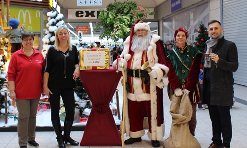 Maria-Theresia Schrader (Foto Klapproth), Karina Karger (Center-Management) und Egzon Hashani (Centermanager) zusammen mit dem Weihnachtsmann und seinem Wichtel. In dem Geschenk befanden sich die Gutescheine. Fotos: Julia Seidel