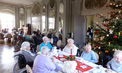 Die Vertreterinnen der Frauenhilfe mit den Bewohnern im adventlich geschmückten Spiegelsaal der Seniorenbetreuung Schloß Schliestedt. Foto: Seniorenbetreuung Schloß Schliestedt