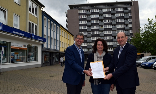 Dr. Oliver Junk (links) und Marion Siegmeier nehmen auf dem Goslarer
Marktplatz den Brief von Matthias Wunderling-Weilbier entgegen, der die Aufnahme in das
Förderprogramm „Soziale Stadt“ verkündet. Foto: Stadt Goslar