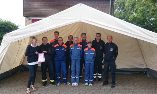 Die Scheckübergabe fand bereits vor dem neuen Zelt statt. Foto: Ortsfeuerwehr Dibbesdorf