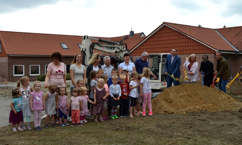 Architekt Ulrich Drößler, Pfarrer Julius Folo Kafuti, Kita- Leiterin Edith Becker und Gemeindedirektor Gero Janze schaufelten symbolisch unter den Blicken der Kinder sowie der Kita-Mitarbeiterinnen für den ersten Spatenstich. Foto: Dirk Fochler