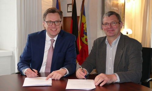 Landrat Dr. Andreas Ebel (links) und Jörg Liedtke, Eigentümer der Gifhorner Cardenapmühle, unterzeichnen den Vertrag zur Ablösung des Alten Wasserrechts für die Cardenapmühle. Foto: Landkreis Gifhorn