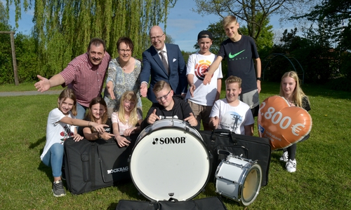 Michael Dambor und Anja Walter (hinten links) vom Spielmanns- und Hörnerzug des Neuen Bürger Corps Peine nahmen gemeinsam mit einigen musizierenden Kindern die Spende von Stefan Honrath, Leiter der Direktion Peine der Volksbank BraWo, entgegen. Foto: Volksbank BraWo 