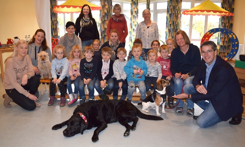 Die Hunde (von links) Penny, Charly und Amy arbeiten zusammen mit Simone Bartels (links) und ihrem Team in der Kita Ohlhof mit den Kindern. Dr. Oliver Junk (rechts) begrüßt zusammen mit Karin Jünke (hinten, Mitte) seine neuen Mitarbeiter.

Foto: Stadt Goslar