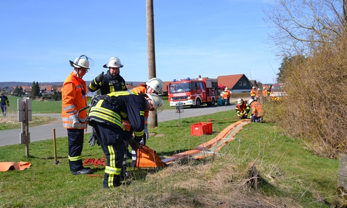 Einsatzkräfte beim Vorbereiten einer Ölsperre, welche auf der Innerste verlegt wurde. Foto: Feuerwehr Sehlde