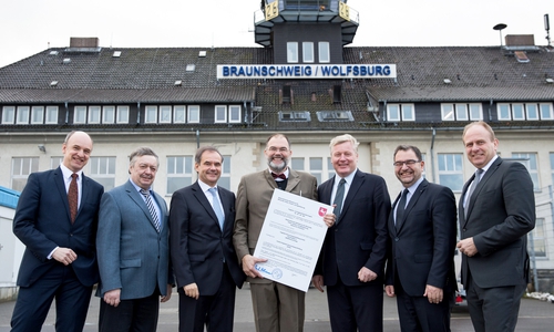 Auf dem Vorfeld des Flughafens Braunschweig-Wolfsburg stehen mit der Urkunde des EASA-Zertifikats: Braunschweigs  Erster Stadtrat Christian Geiger, Bürgermeister Günter Lach (Stadt Wolfsburg), Braunschweigs Oberbürgermeister Ulrich Markurth, Flughafen-Geschäftsführer Boris Gelfert, Wirtschaftsminister Dr. Bernd Althusmann sowie Flughafen-Aufsichtsräte Sabah Enversen (Wolfsburg) und Gerhard Radeck (Helmstedt) (v. li.). Foto: Stadt Braunschweig/Daniela Nielsen