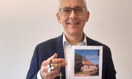 Superintendent Christian Berndt zeigt Konfirmationskreuze.