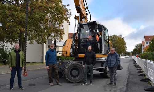 Manfred und Carsten Kreie (von rechts) von der ausführenden Firma Kreie Baumanagement GmbH stehen mit ihren Mitarbeitern und dem Bagger in den Startlöchern. Zum Auftakt der Baustelle schauen Mathias Brand (von links), Fachdienstleiter Tiefbau, sowie Sachbearbeiter Thomas Janeck in der Bromberger Straße vorbei.