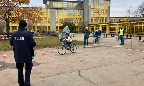 Alle dürfen ihr Geschick auf dem Fahrrad beweisen. Der Polizeibeamte schaut zu.