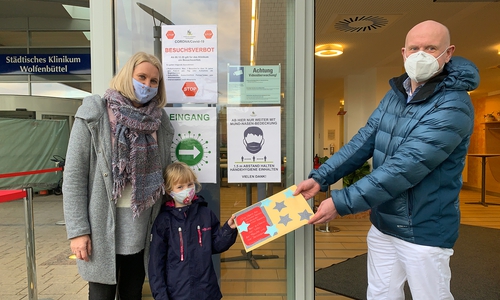 Stephanie Gäbel, Leiterin Kita Alter Weg, und Nike (5 Jahre) übergaben die Bilder an Dr. Tobias Jüttner, Chefarzt der Klinik für Anästhesie, operative Intensiv-, Notfall- und Schmerzmedizin.