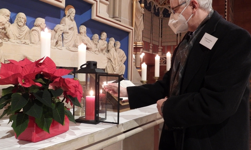 Kirchenvorsteher Frank Neubauer zündet ein Friedenslicht an. 