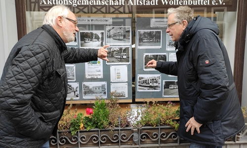 Heftautor Jürgen Hunger und Vereinsvorsitzender Dieter Kertscher vor dem Schaufenster der Aktionsgemeinschaft Altstadt Wolfenbüttel im Kleinen Zimmerhof. Hier bekommen Interessierte Informationen zur ehemaligen Straßenbahn in Wolfenbüttel präsentiert.