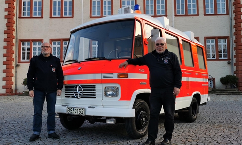 Der Infektionstransportwagen vor dem Städtischen Museum Schloss Salder mit den beiden Überbringern Ralf Wiese (links), Hans-Ludwig Sämann (rechts) vom Förderverein Feuerwehr und Jugendfeuerwehr Braunschweig e. V.