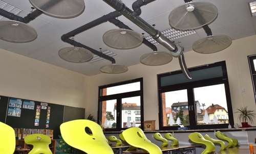 An der Decke des Klassenraums leiten Plastikhauben und Rohre die ausgeatmete Luft und Aerosole nach draußen.