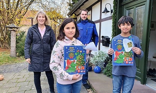 Die Feuerwehrkinder Lisa und Krish freuen sich über die von den Betreuern mitgebrachten Adventskalendern.