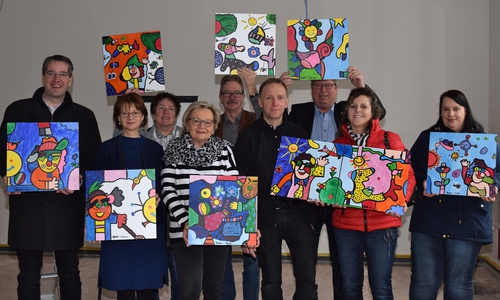 16 Einzelbilder ergeben zusammen an der Wand ein Ganzes. Oberbürgermeister Dr. Oliver Junk (von links), Kirsten Brocks, Leiterin der Stadtbibliothek, Monika Beushausen und Ingried Gröne von Vorstand des Mütterzentrums, Christoph Gutmann, Fachdienstleiter Kultureinrichtungen und wissenschaftliche Dienste, Artur Dorn, Projektleiter im Umbau des Kulturmarktplatzes, Erster Stadtrat Burkhard Siebert, Birgit Wedra, Vorstand Mütterzentrum, und Viktoria Grams von der Stadtbibliothek präsentieren in der künftigen Kinderbuchabteilung schon einen Teil des ganzen Kunstwerks.