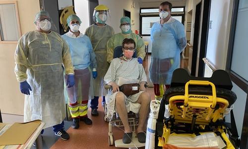 Freuen sich mit dem Patienten: Mitarbeiter, Pflegekräfte der Harzklinik Goslar (in gelber Schutzkleidung),  mit zwei Sanitätern des Rettungswagens, die den Patienten zurück nach Zwolle/ Niederlande bringen.