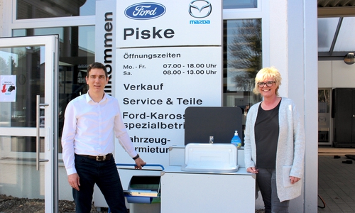 Serviceleiter Christian Bosse und Serviceassistentin Susanne Dotzauer vor dem portablen Waschbecken.