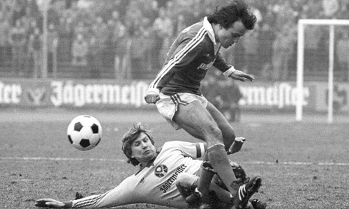 Auch gegen ehemalige Mitspieler nicht zimperlich: Beim 1:0-Sieg gegen Dortmund am 22. März 1980 grätscht Merkhoffer auch Wolfgang Frank ab.