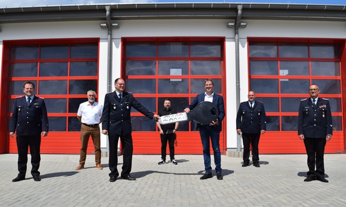 Dr. Oliver Junk (3. v. rechts) übergibt den symbolischen Schlüssel an Martin Kowalewsky. Mit ihnen freuen sich (von links) sein Stellvertreter Oliver Voß, Ortsvorsteher Eckhard Wagner, Giovanni Graziano als Vorsitzender des Ausschusses für Sicherheit, Ordnung und Sport, Jürgen Koch, stellvertretender Stadtbrandmeister, und Stadtbrandmeister Christian Hellmeier.
