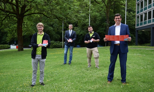 Sparkassenregionaldirektor Jens Müller (rechts), Oberbürgermeister Dr. Oliver Junk (2.v.li.), sowie Joshua Friederichs (links) und Martin Sänger von der Stadtjugendpflege präsentieren den Ferienpass 2020.