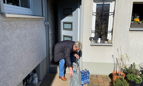 Eine Frau freut sich über die Einkaufshilfe der Jusos.