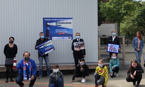 Polizeidirektorin Krischker ,PHKìn Goberack, Grafik-Designer Velte und Projektleiter Koschig überreichen den Preis an Schulleiterin Claudia Kohl.