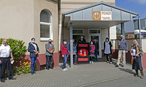 Vertreter von Tafel, Kirche, Landkreis, Stadt und Polizei vor dem Gebäude der Peiner Tafel.