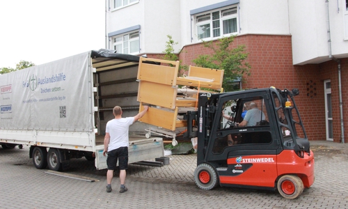 Die Betten werden auf den Transporter geladen. 