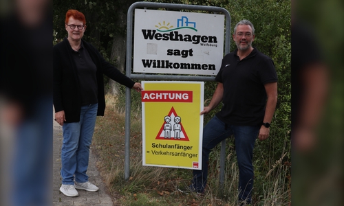 Dr. Christa Westphal-Schmidt, stellvertretende Ortsbürgermeisterin von Westhagen, und Matthias Bussler, Vorsitzender des SPD-Ortsvereins Westhagen, mit einem SPD-Plakat zum Schulanfang. 