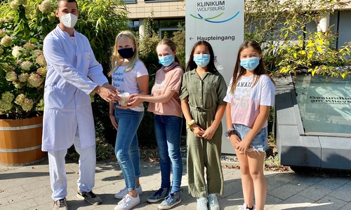 Übergabe am Klinikum: Dr. Alexander Behrens nimmt von den vier Schülerinnen den gut gefüllten Spendentopf entgegen.     