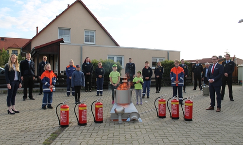 Vertreter der Kinder- und Jugendfeuerwehren testen zusammen mit den Volksbank BraWo-Mitarbeitern Sabrina Keunecke (links) und Max Heinrich (rechts) die neue Übungsfeuerlöschanlage.