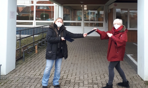 Yvonne Franke nimmt die Tabletts aus der Hand von Eva Fuhrmann entgegen.