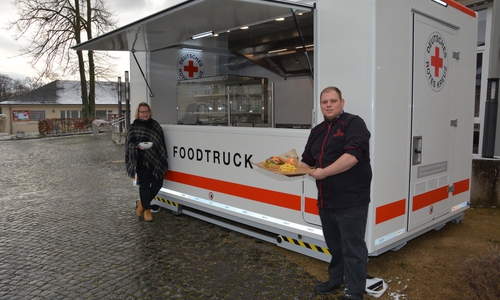 Corina Bornecke (links) und Sascha Bartels mit dem Klassiker, dem Burger, vor dem neuen Foodtruck.