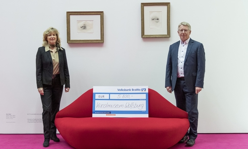 Otmar Böhmer, Geschäftsführer des Kunstmuseums Wolfsburg, nimmt eine Spende von Claudia Kayser, Leiterin der Direktion Wolfsburg der Volksbank BraWo, entgegen.