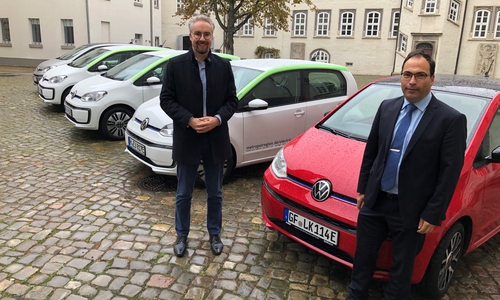 Dr. Thomas Walter (Erster Kreisrat, links) und Jochen Koslowski (Leitung Fachbereich Zentrale Dienste) präsentieren die neuen E-Fahrzeuge im Fuhrpark der Kreisverwaltung. 