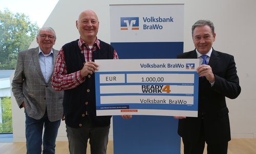 Klaus-Jürgen Herzberg (M.), Vorstandsmitglied bei ready4work, nimmt im Beisein vom ehemaligen Vereinsvorstand Albrecht Düsel (l.) die Spende von Thomas Fast, Leiter der Direktion Gifhorn der Volksbank BraWo, entgegen.