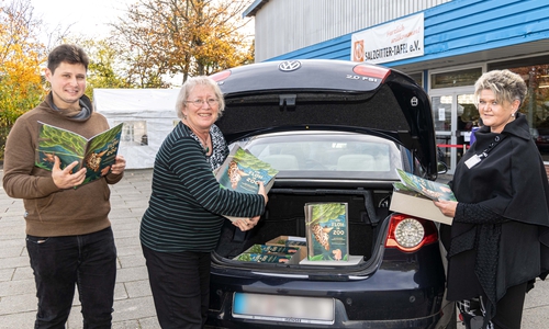 Eugen Schmidt vom Kinderschutzbund und Monika Jüntschke vom Freiwilligenzentrum übergeben die Malhefte an Bettina Moldehn von der Tafel Salzgitter.