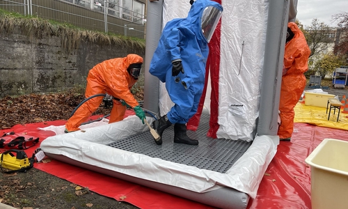 Dekontamination einer Einsatzkraft in einem Chemikalien-Schutzanzug.