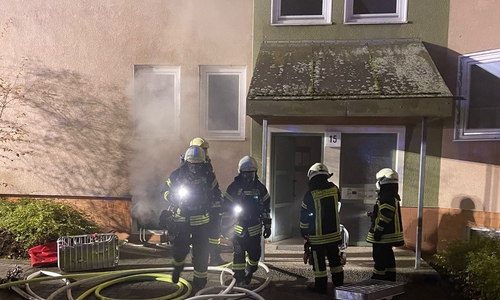 Rauch quillt aus dem Kellerfenster des Brandhauses. 