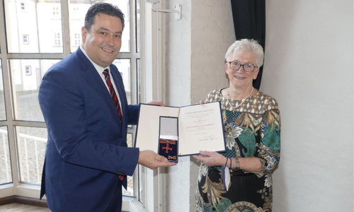 Landrat Tobias Heilmann übergibt das Verdienstkreuz am Bande des Verdienstordens an Ilsemarie Dralle.