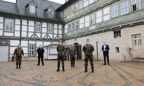 Oberstleutnant Reiner Rotzek, Fregattenkapitän Patrick Domagalski, Gefreiter Jana Schneider, Oberstleutnant Ralph Marschner, Obermaat Daniel Otto und Kai Lauenroth (Leiter des GDA Schwiecheldthaus) vor dem historischen Gebäudeensemble des Schwiecheldthaus in der Goslar Altstadt.